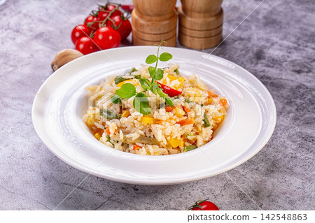 Vegetable fried rice with bell peppers and pea shoots on white plate Vegetable fried rice with bell peppers and pea shoots on white plate 142548863