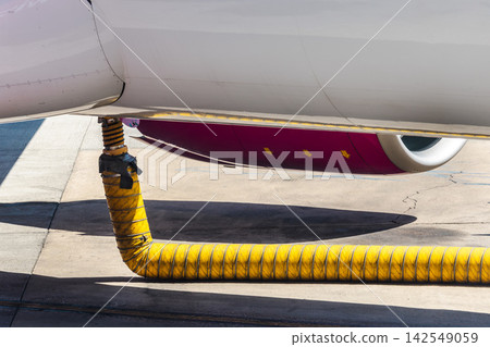 Close-Up of Aircraft Underside and Yellow Ground Service Hose Close-Up of Aircraft Underside and Yellow Ground Service Hose 142549059