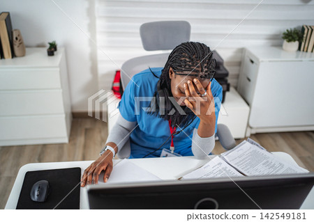 Stressed healthcare worker experiencing medical burnout in office Stressed healthcare worker experiencing medical burnout in office 142549181