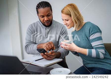 Diverse colleagues collaborating, discussing content on a smartphone Diverse colleagues collaborating, discussing content on a smartphone 142549242