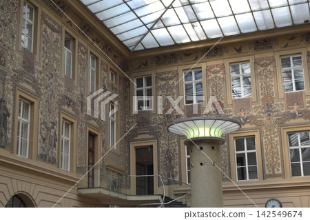 Ornate postal atrium interior with large skylight and frescoed walls in prague for architectural background and banner design Ornate postal atrium interior with large skylight and frescoed walls in prague for architectural background and banner design 142549674