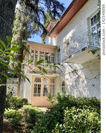 Historic Chekhov house with ornate balcony and veranda among mature garden trees Historic Chekhov house with ornate balcony and veranda among mature garden trees 142549899