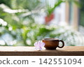 Wooden cup and purple orchid flower on wooden table with nature background 142551094