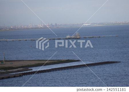 蔚藍的海洋、朦朧的工業區城市景觀和蔚藍的天空構成了一幅美麗的畫卷。 蔚藍的海洋、朦朧的工業區城市景觀和蔚藍的天空構成了一幅美麗的畫卷。 142551181