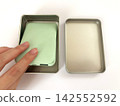 A swollen mobile battery placed in a metal can - white background 142552592