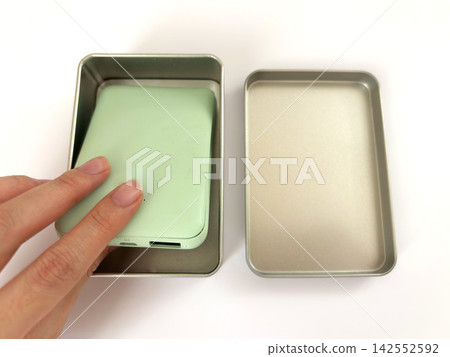 A swollen mobile battery placed in a metal can - white background A swollen mobile battery placed in a metal can - white background 142552592