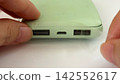 The process of insulating the USB port of a swollen mobile battery with tape. 142552617