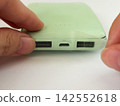 The process of insulating the USB port of a swollen mobile battery with tape. 142552618