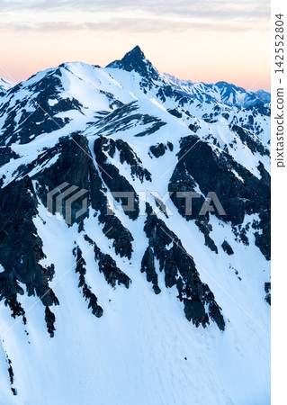 Early morning view of Mt. Yarigatake from Kitahotaka Hut (magic hour) - Climbing Mt. Kitahotaka in the Northern Alps during early summer when snow remains. Early morning view of Mt. Yarigatake from Kitahotaka Hut (magic hour) - Climbing Mt. Kitahotaka in the Northern Alps during early summer when snow remains. 142552804
