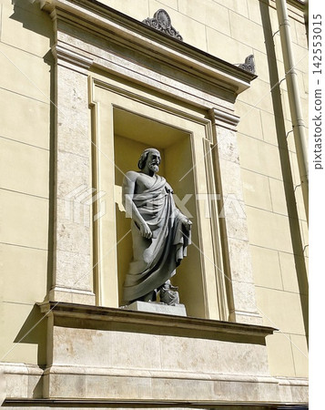 Classical stone statue in architectural niche illuminated by bright natural sunlight 142553015
