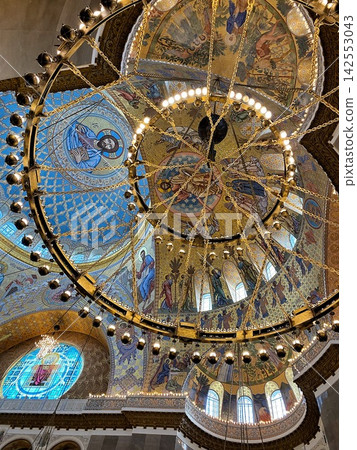 Ornate cathedral dome with colorful mosaics and grand chandelier in natural light Ornate cathedral dome with colorful mosaics and grand chandelier in natural light 142553043