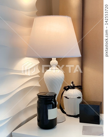 Elegant Table Lamp with Candle and Perfume on Minimalist Nightstand Elegant Table Lamp with Candle and Perfume on Minimalist Nightstand 142553720