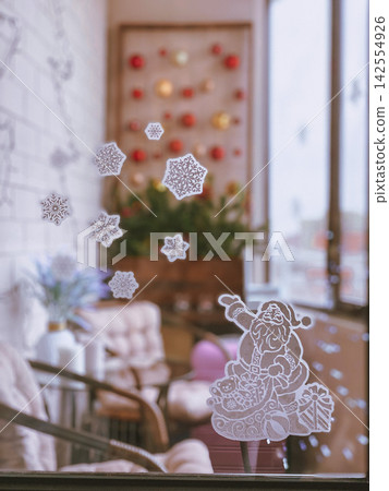 Christmas window stickers with Santa and snowflakes, cozy indoor festive interior Christmas window stickers with Santa and snowflakes, cozy indoor festive interior 142554926