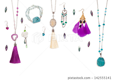 Handmade turquoise and purple bijouterie with gems, tassels and feathers, lying flat on the white horizontal background, top view Handmade turquoise and purple bijouterie with gems, tassels and feathers, lying flat on the white horizontal background, top view 142555141