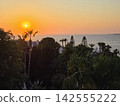 Beautiful Mediterranean sea sunset with coastal villas and palm tree 142555222