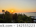 Beautiful Mediterranean sea sunset with coastal villas and palm tree 142555223