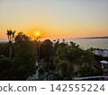Beautiful Mediterranean sea sunset with coastal villas and palm tree 142555224