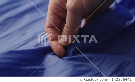 man hand checking blue synthetic bag fabric man hand checking blue synthetic bag fabric 142556441