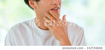 Men who touch their chins while being conscious of beard removal or skincare. Men who touch their chins while being conscious of beard removal or skincare. 142556668