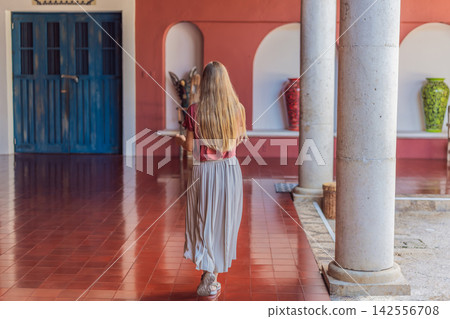 Female tourist walks and twirls through colonial arches, tiled floors and stone details, showing Mexico travel, culture and elegant vacation style concept Female tourist walks and twirls through colonial arches, tiled floors and stone details, showing Mexico travel, culture and elegant vacation style concept 142556708
