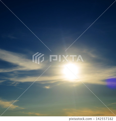 bright sun shines brightly in a blue sky with translucent feathery clouds on a clear day 142557182