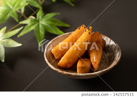 光澤誘人的蜜餞紅薯,以日式背景拍攝。 光澤誘人的蜜餞紅薯,以日式背景拍攝。 142557515