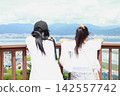 Two elementary school sisters gazing at the lake Two elementary school sisters gazing at the lake 142557742