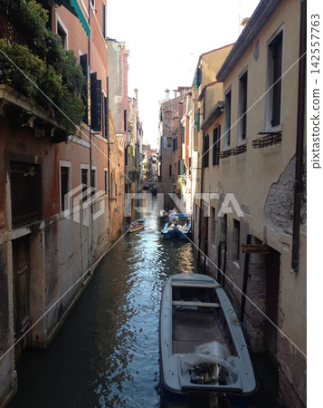 The quiet back canals of Venice: Sunlight streaming into small boats and old streets The quiet back canals of Venice: Sunlight streaming into small boats and old streets 142557763