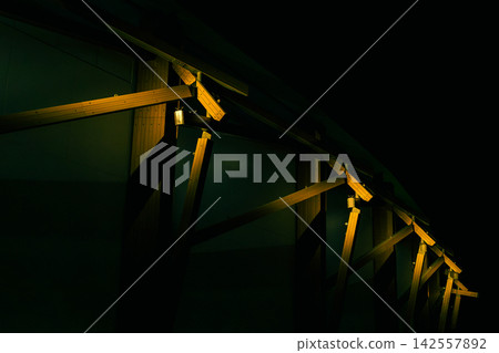 Modern architectural timber structures and geometric frames illuminated in the dark night Modern architectural timber structures and geometric frames illuminated in the dark night 142557892