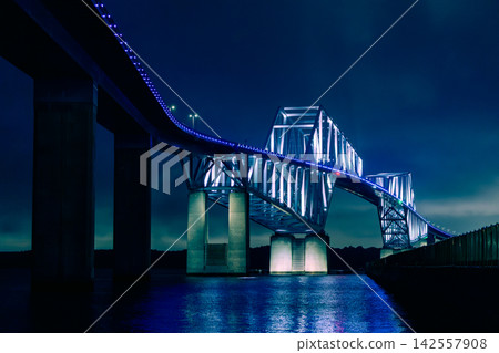 東京門大橋和夜幕下的東京灣,夜晚燈光璀璨,呈現藍色的光芒。 東京門大橋和夜幕下的東京灣,夜晚燈光璀璨,呈現藍色的光芒。 142557908