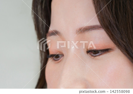 Skincare and beauty image of a 40-something woman with a striking downcast expression. Skincare and beauty image of a 40-something woman with a striking downcast expression. 142558098