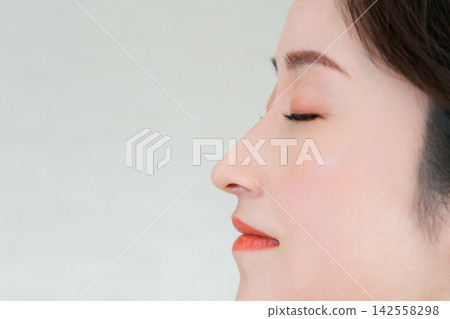 一位四十多歲女性的側面特寫,她高挺的鼻樑和輪廓分明的下顎線令人印象深刻。 一位四十多歲女性的側面特寫,她高挺的鼻樑和輪廓分明的下顎線令人印象深刻。 142558298