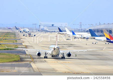 An airplane prepares for takeoff on the runway at Kansai International Airport in Osaka Prefecture. 142558456