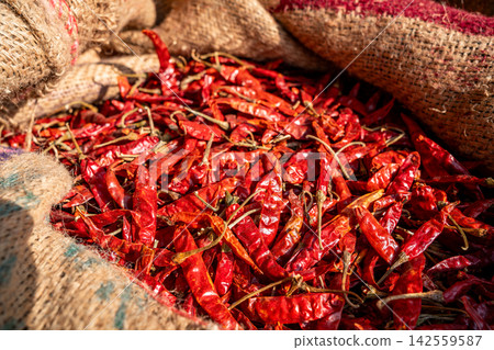 Dried red chili peppers in a burlap sack Dried red chili peppers in a burlap sack 142559587