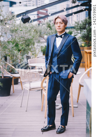 A man in a tuxedo stands on the terrace. A man in a tuxedo stands on the terrace. 142559901