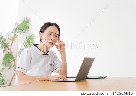 美容院的一名女員工心事重重。 美容院的一名女員工心事重重。 142560919
