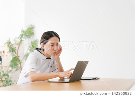 美容院的一名女員工心事重重。 美容院的一名女員工心事重重。 142560922