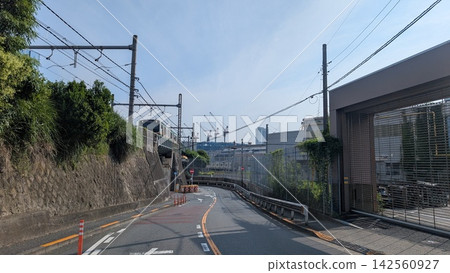 A train running along a road next to the railway tracks. A train running along a road next to the railway tracks. 142560927