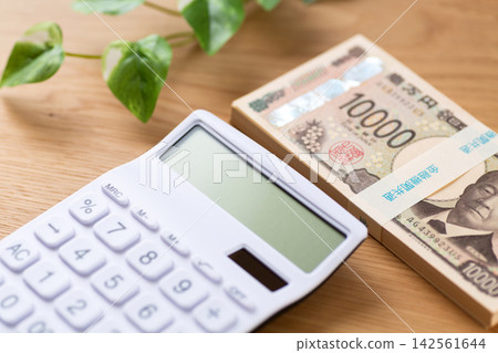 A stack of 1 million yen bills and a calculator A stack of 1 million yen bills and a calculator 142561644