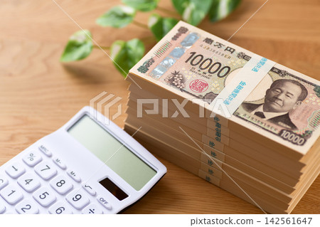一疊800萬日圓鈔票和一個計算器 一疊800萬日圓鈔票和一個計算器 142561647