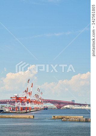 大阪南港的龍門起重機和港大橋在盛夏的天空下延伸開來，天空佈滿了巨大的白色積雨雲。 142561805