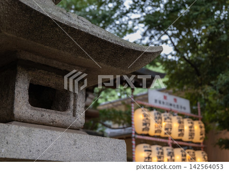 神社裡的石燈籠,背景透出紙燈籠的光芒。 神社裡的石燈籠,背景透出紙燈籠的光芒。 142564053