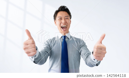 一位男商人面帶微笑地慶祝自己的成功。 一位男商人面帶微笑地慶祝自己的成功。 142564118