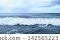 Large white waves crashing against the sea in Shonan under a cloudy sky. 142565223