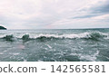 The cloudy sky over the Shonan coast and the crashing white waves. 142565581