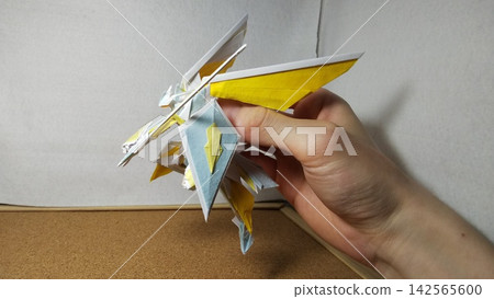 A creative origami creation depicting a knight of the sky, wielding a one-handed sword and shield, and soaring through the air on his wings. A creative origami creation depicting a knight of the sky, wielding a one-handed sword and shield, and soaring through the air on his wings. 142565600