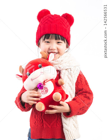 Smiling little girl hugging a red ox plush toy, celebrating the Year of the Ox, Chinese New Year theme.The Chinese character embroidered above: "Fu" (Good Fortune) Smiling little girl hugging a red ox plush toy, celebrating the Year of the Ox, Chinese New Year theme.The Chinese character embroidered above: "Fu" (Good Fortune) 142566531