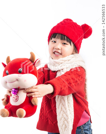 Smiling little girl hugging a red ox plush toy, celebrating the Year of the Ox, Chinese New Year theme.The Chinese character embroidered above: "Fu" (Good Fortune) 142566533