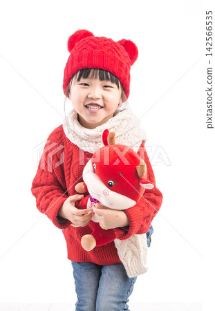 Smiling little girl hugging a red ox plush toy, celebrating the Year of the Ox, Chinese New Year theme. 142566535
