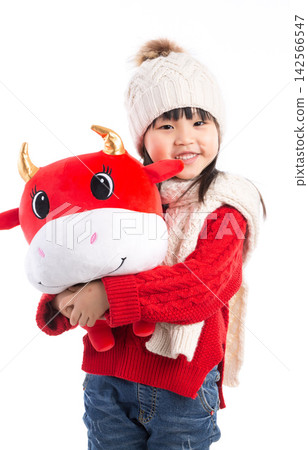 Smiling little girl hugging a red ox plush toy, celebrating the Year of the Ox, Chinese New Year theme. Smiling little girl hugging a red ox plush toy, celebrating the Year of the Ox, Chinese New Year theme. 142566547